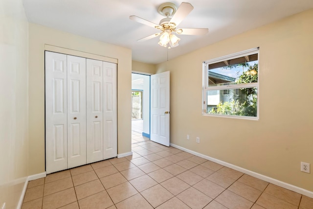 unfurnished bedroom with a closet, ceiling fan, and light tile patterned floors