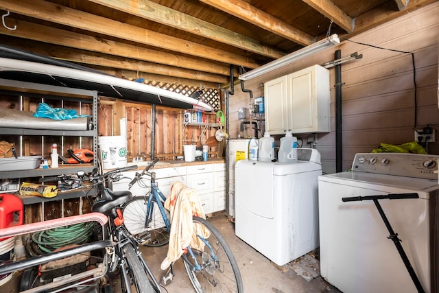 washroom featuring washer and dryer, cabinets, and water heater