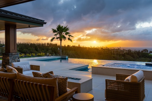 210 Naio Pl, Lahaina, HI 96761 - pool at dusk with a hot tub, an outdoor living space with a fire pit, an infinity pool, and a patio