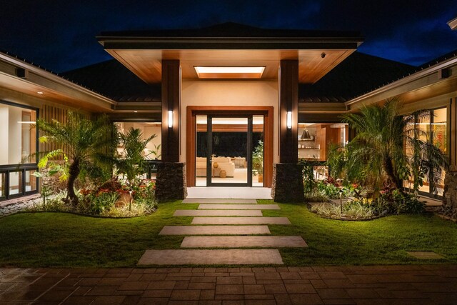 210 Naio Pl, Lahaina, HI 96761 - exterior entry at twilight featuring a standing seam roof, metal roof, a lawn, and stucco siding