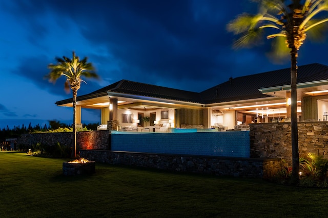 210 Naio Pl, Lahaina, HI 96761 - back of house at twilight featuring an outdoor fire pit, a yard, and metal roof