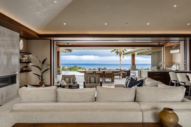 210 Naio Pl, Lahaina, HI 96761 - living room featuring a premium fireplace, vaulted ceiling, and a water view