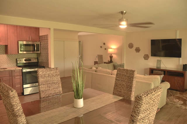 dining space with dark wood-type flooring and ceiling fan