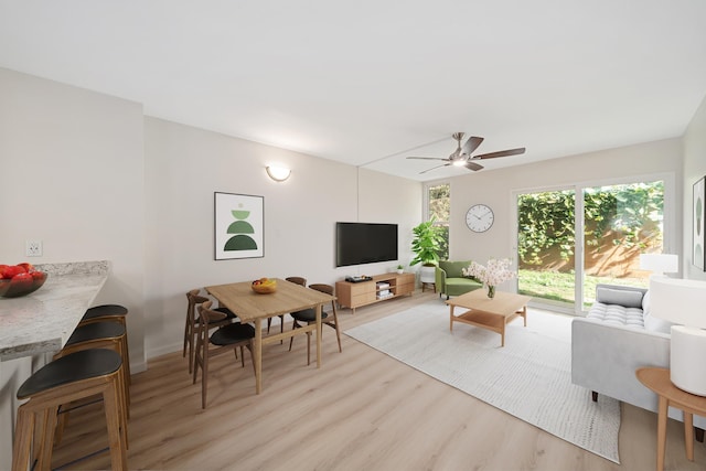 living area with light wood-style flooring and ceiling fan