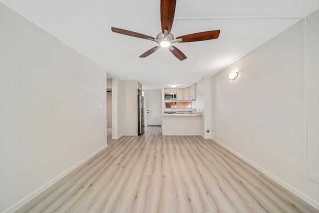 unfurnished living room featuring a ceiling fan, light wood-type flooring, and baseboards