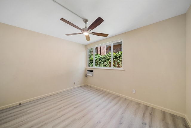 unfurnished room with a ceiling fan, a wall unit AC, light wood-style flooring, and baseboards