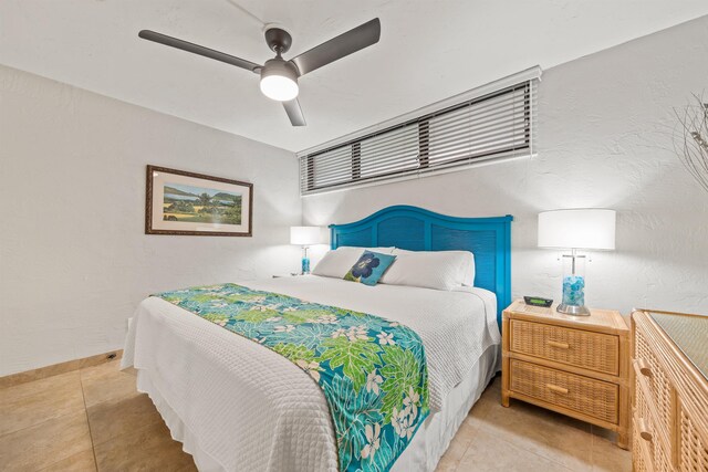 tiled bedroom with baseboards, a ceiling fan, and a textured wall