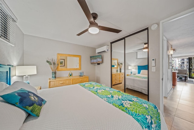 tiled bedroom with a ceiling fan, a closet, and a wall mounted AC