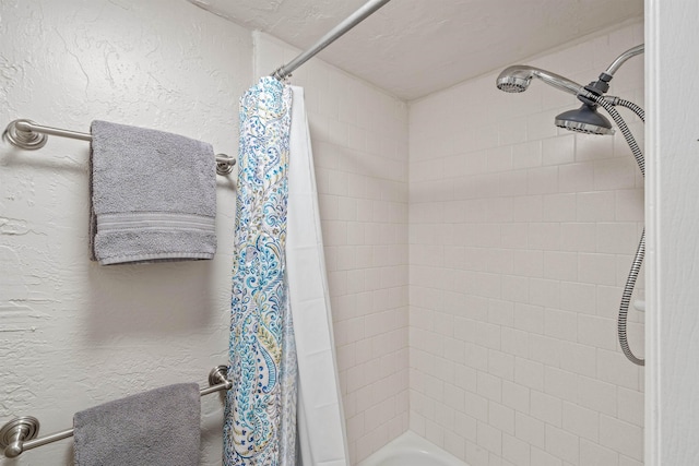 bathroom featuring a textured wall and shower / tub combo