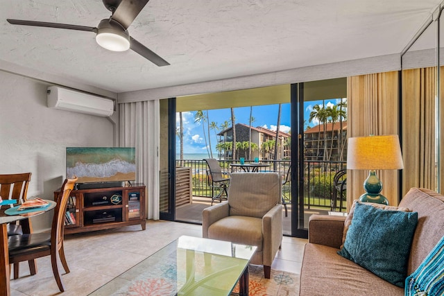 living area featuring a wall unit AC, a textured wall, ceiling fan, a textured ceiling, and a wall of windows