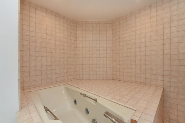 bathroom with tile walls, a tub, and tile patterned floors