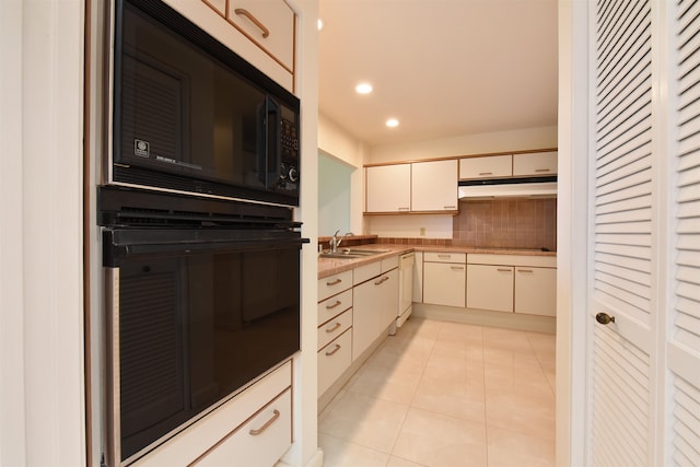 kitchen with cream cabinetry, black appliances, sink, decorative backsplash, and light tile patterned flooring