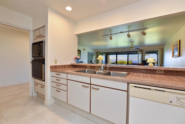 kitchen featuring black appliances, tile counters, sink, rail lighting, and ceiling fan