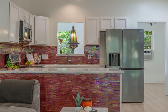 568 Hana Hwy Unit B, Paia, HI 96779 - kitchen featuring appliances with stainless steel finishes, a sink, white cabinets, and tasteful backsplash