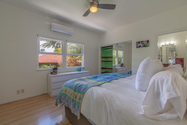 568 Hana Hwy Unit B, Paia, HI 96779 - bedroom with a wall unit AC, light wood-style flooring, a ceiling fan, and baseboards