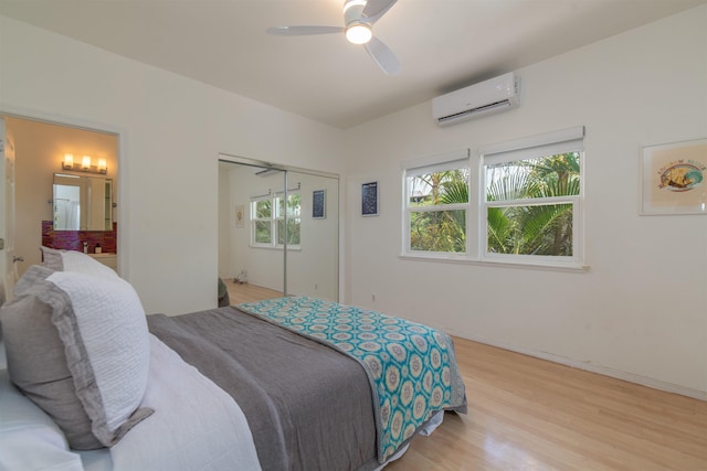 568 Hana Hwy Unit B, Paia, HI 96779 - bedroom featuring an AC wall unit, light wood-style flooring, ceiling fan, ensuite bathroom, and baseboards