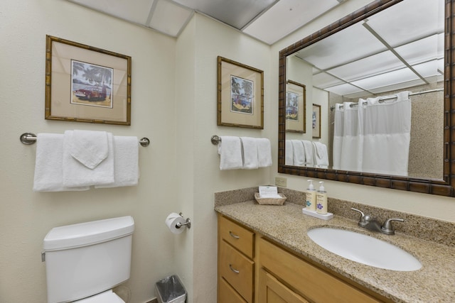 bathroom featuring a shower with curtain, vanity, and toilet