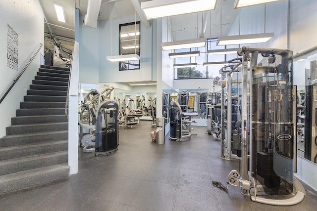 workout area featuring a towering ceiling