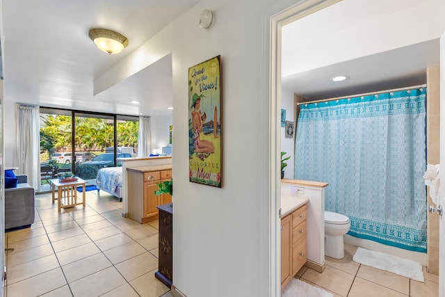 bathroom with tile flooring, toilet, and vanity