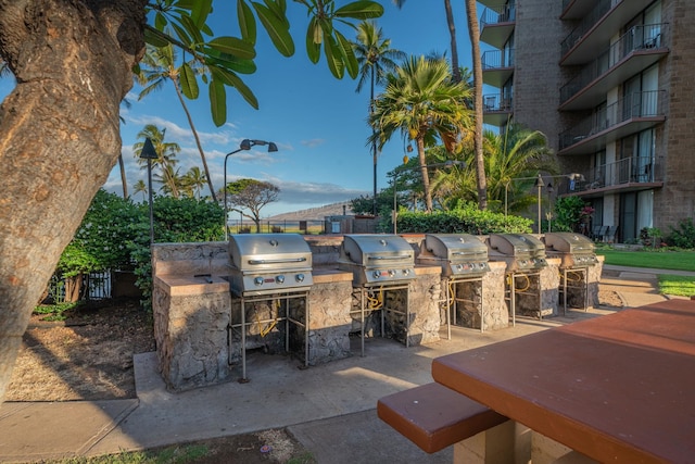 view of patio / terrace featuring exterior kitchen, a balcony, and a grill