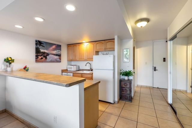 kitchen featuring white appliances, sink, kitchen peninsula, and light tile flooring