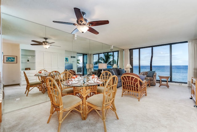 dining space with carpet flooring, floor to ceiling windows, and ceiling fan