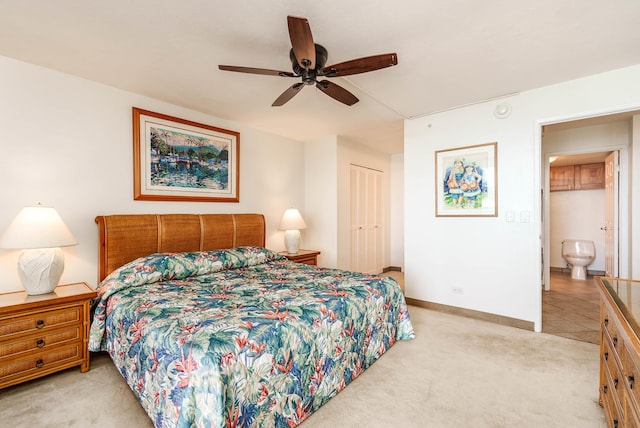 bedroom with a ceiling fan, a closet, light carpet, and baseboards