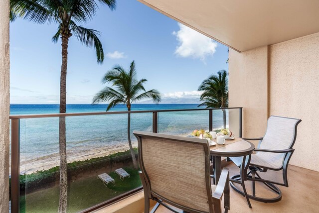 balcony featuring a water view and a beach view