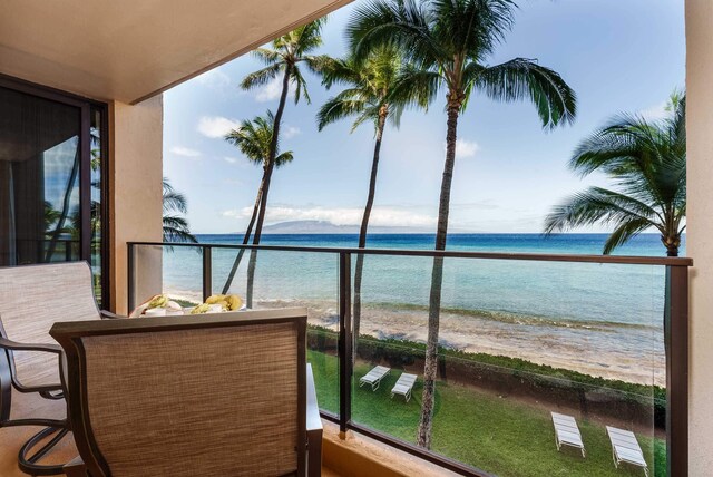 balcony featuring a water view and a view of the beach