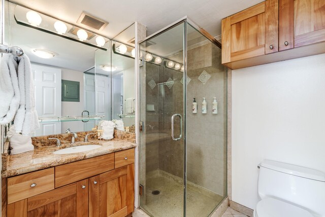 bathroom featuring walk in shower, toilet, and vanity