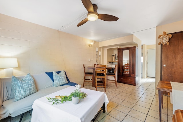 living area with light tile patterned flooring and a ceiling fan