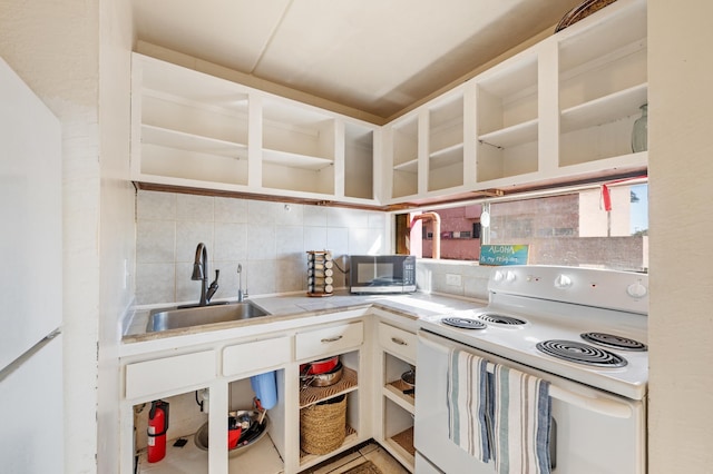 kitchen featuring tasteful backsplash, open shelves, light countertops, white appliances, and a sink