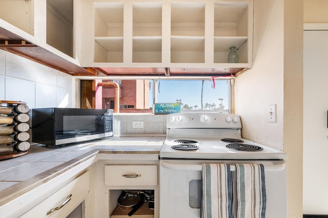 kitchen featuring backsplash, glass insert cabinets, tile counters, white cabinetry, and white electric range