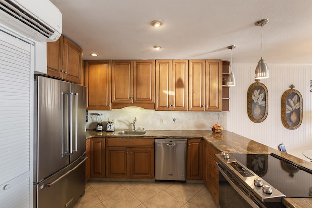 kitchen with dark stone counters, sink, appliances with stainless steel finishes, a wall mounted AC, and decorative light fixtures