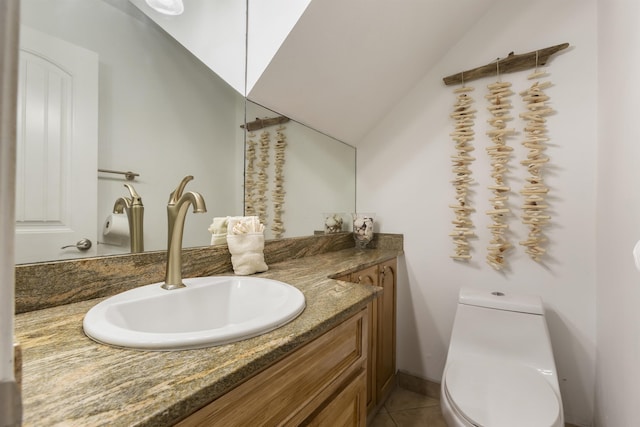 bathroom with tile patterned flooring, vanity, lofted ceiling, and toilet