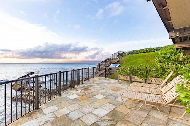 view of patio / terrace featuring a water view, a beach view, and a balcony