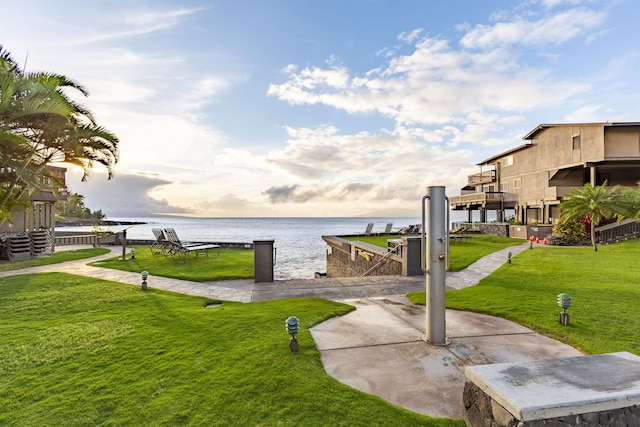 exterior space featuring a lawn and a water view