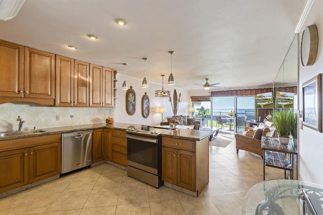 kitchen with kitchen peninsula, range with electric cooktop, stainless steel dishwasher, sink, and decorative light fixtures