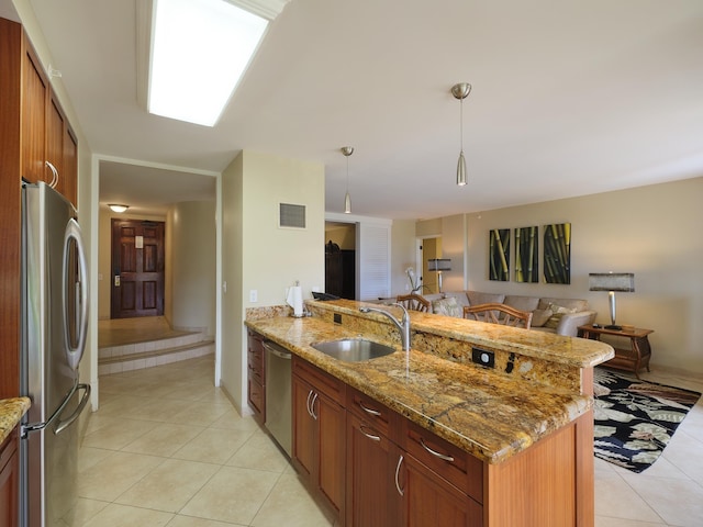 kitchen with light stone countertops, pendant lighting, light tile patterned floors, appliances with stainless steel finishes, and sink