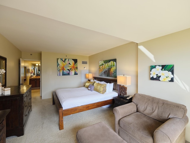 bedroom with connected bathroom and light colored carpet