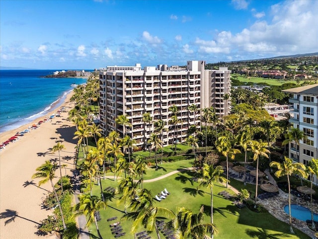 view of building exterior featuring a water view and a view of the beach