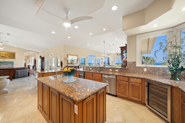 kitchen with hanging light fixtures, wine cooler, stainless steel dishwasher, kitchen peninsula, and lofted ceiling