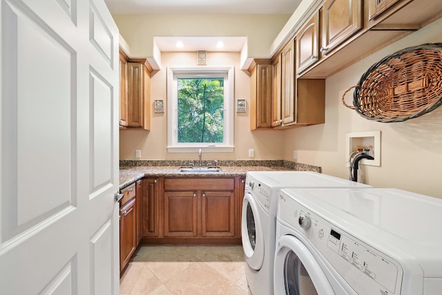 laundry area featuring washer and clothes dryer, cabinets, light tile patterned floors, and sink