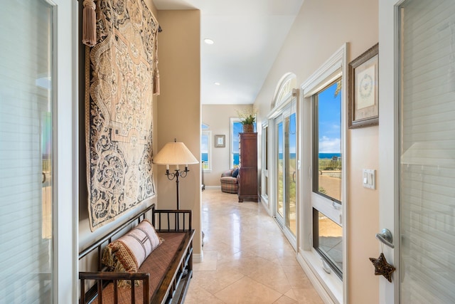 hallway with plenty of natural light and light tile patterned flooring