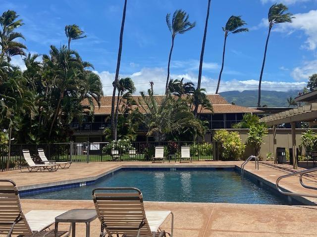 community pool with a patio area and fence