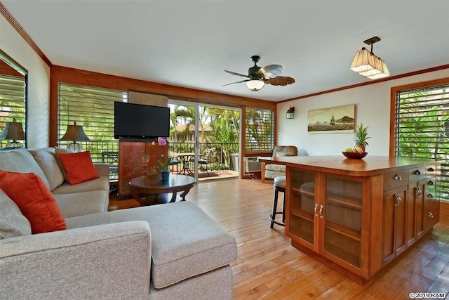 living room featuring a ceiling fan, crown molding, and light wood-style flooring