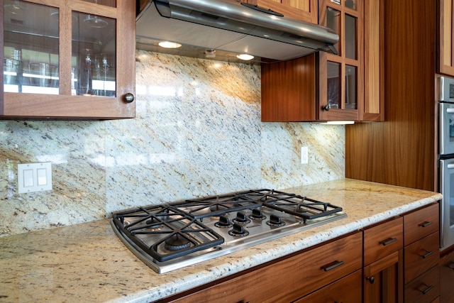 1387 Hihimanu St Unit 16, Kihei, HI 96753 - kitchen with ventilation hood, backsplash, light stone counters, and stainless steel appliances