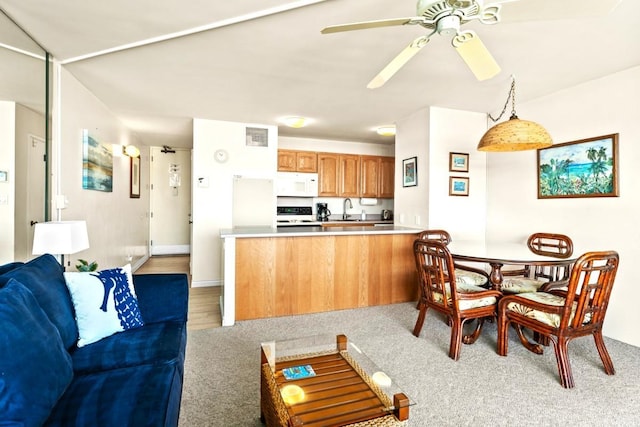 kitchen featuring ceiling fan, sink, kitchen peninsula, pendant lighting, and white appliances