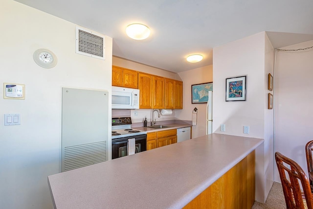 kitchen featuring kitchen peninsula, sink, and white appliances