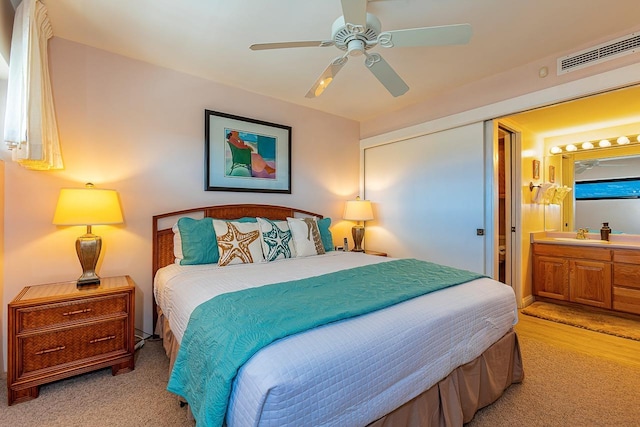 bedroom with ceiling fan, sink, and ensuite bath